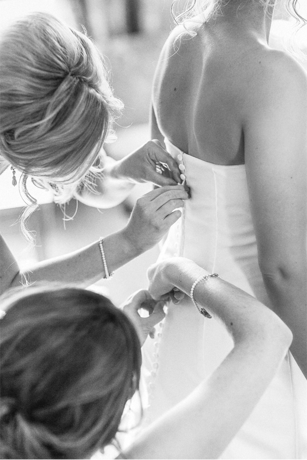 wedding at stonefiled castle bride having her dress buttoned 