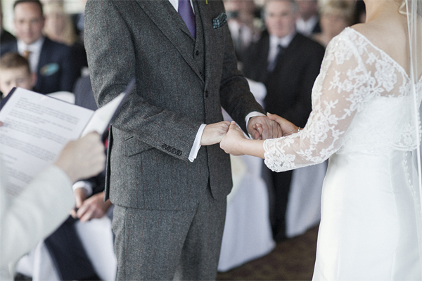 bride and groom holding hands during ceremony