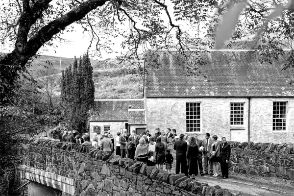 wedding guests gathers in front of a scottish church