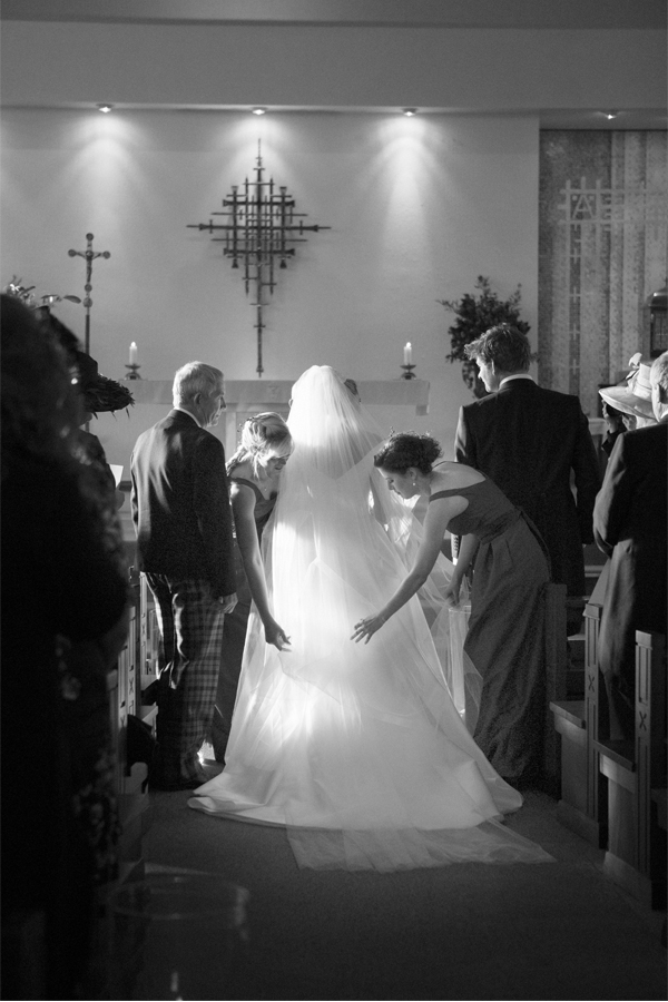bride having her dress and veil fixed at church ceremony