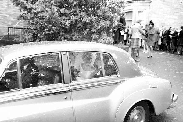 newlyweds leaving teh church in a wedding car