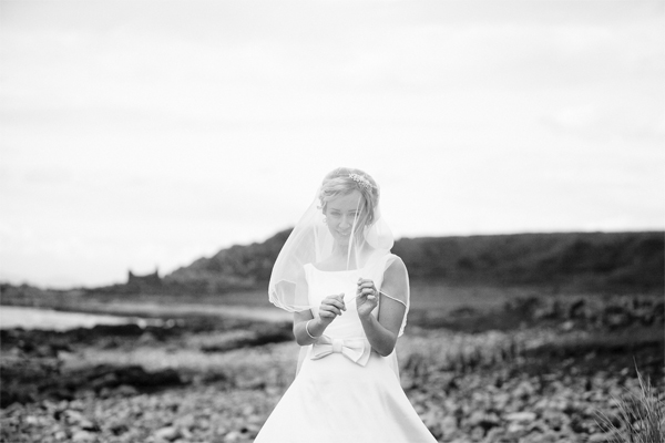 bride playing with his veil on a beach
