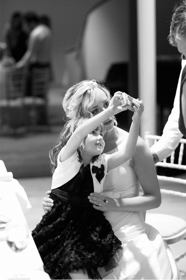 little girl take photo with bride
