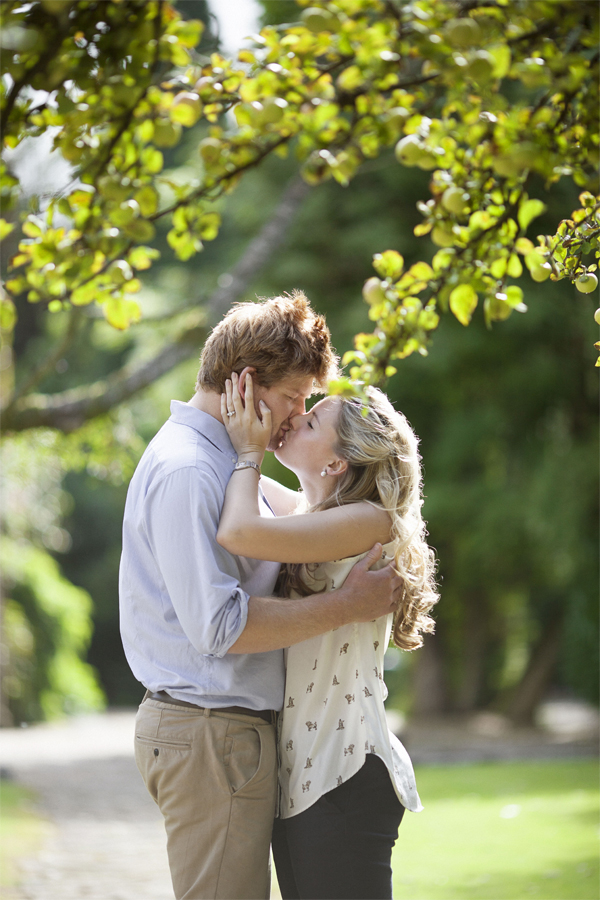 engaged couple kissing under an apple tree garden glasgow