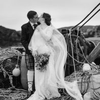 married couple kissing in an old harbour scotland isle of harris