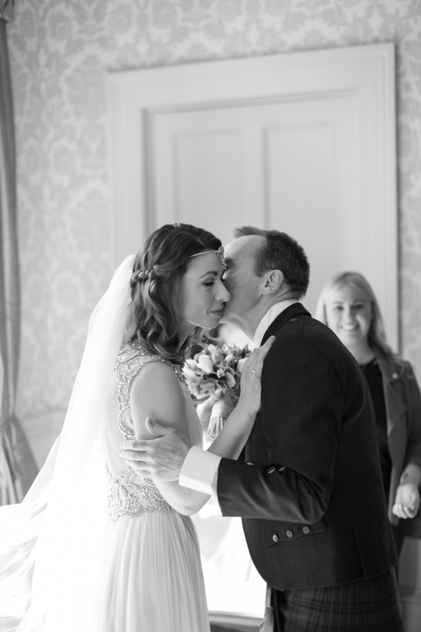 father kissing the bride after seeing her in the wedding dress