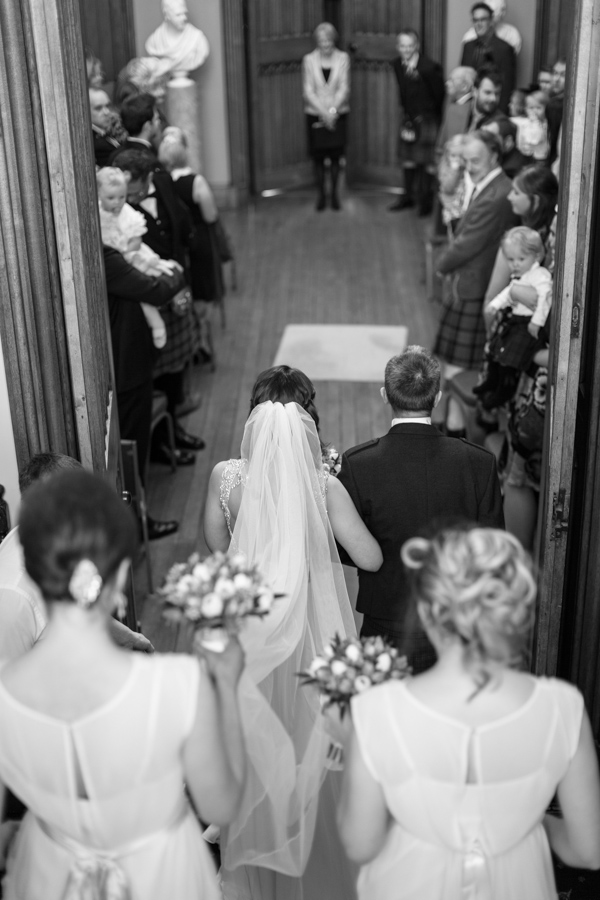 bride walking down with father and bridesmates for ceremony