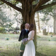 couple kissing during wedding under tree at blairquhan castle wedding photographer ayrshire