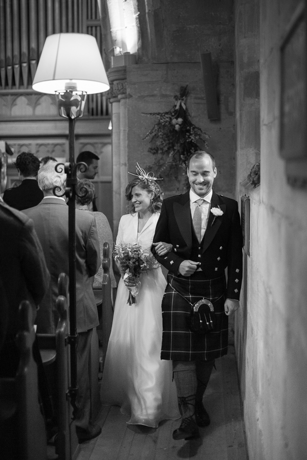 newlyweds walk out of the church near edinburgh