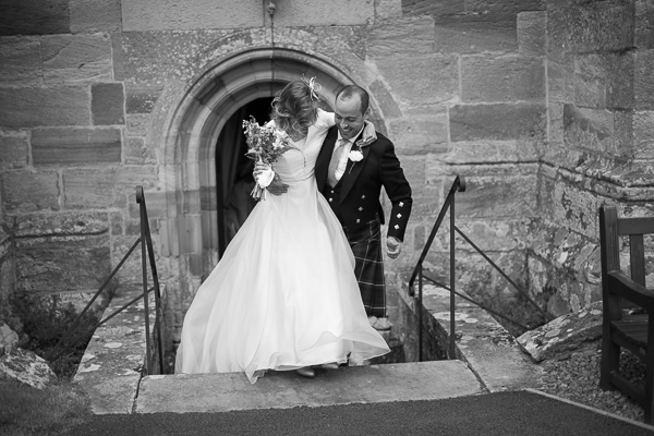 groom lifts the bride on the steps from the church fotogenic of scotland
