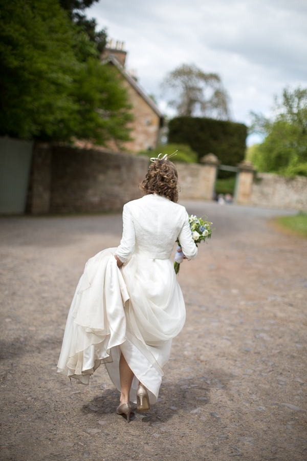 bride walking alone holding her dress