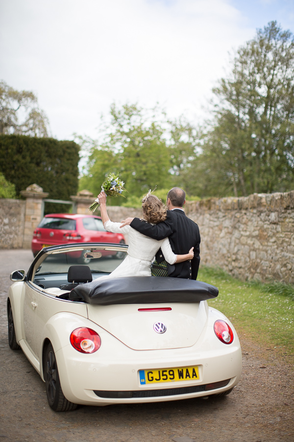newlyweds driving away in a VW beattle in edinburgh scotland