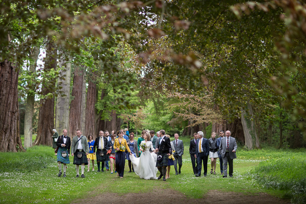bride and groom leading the procession of guests to wedding venue near edinburgh