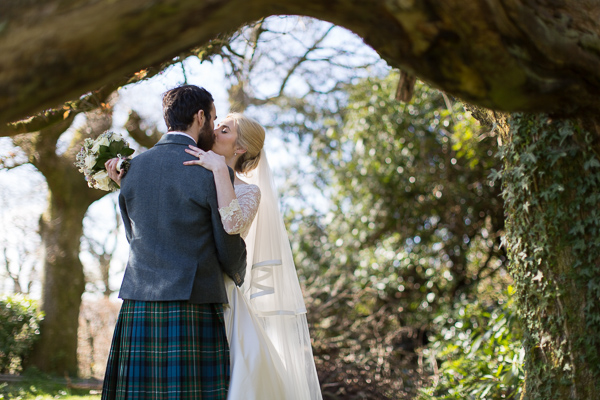 just married kissing under a large tree loch lomond wedding photographer