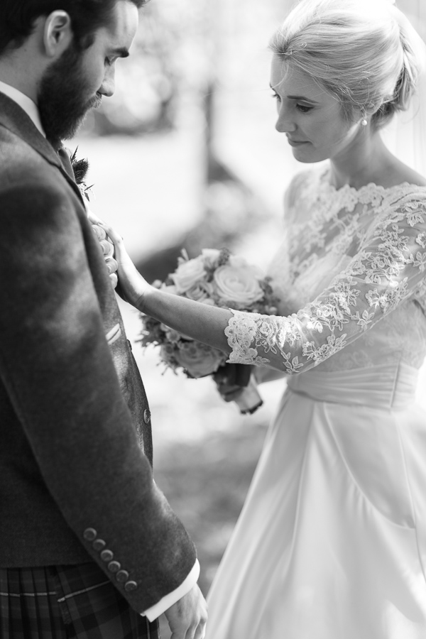 newlyweds looking down on their wedding rings at boturich castle