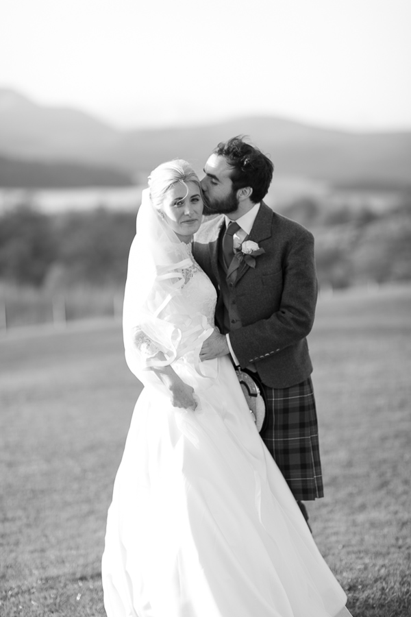 groom kissing bride in a cheek at boturich castle