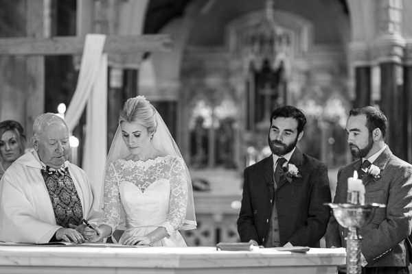 bride signing the register at church ceremony in scotland