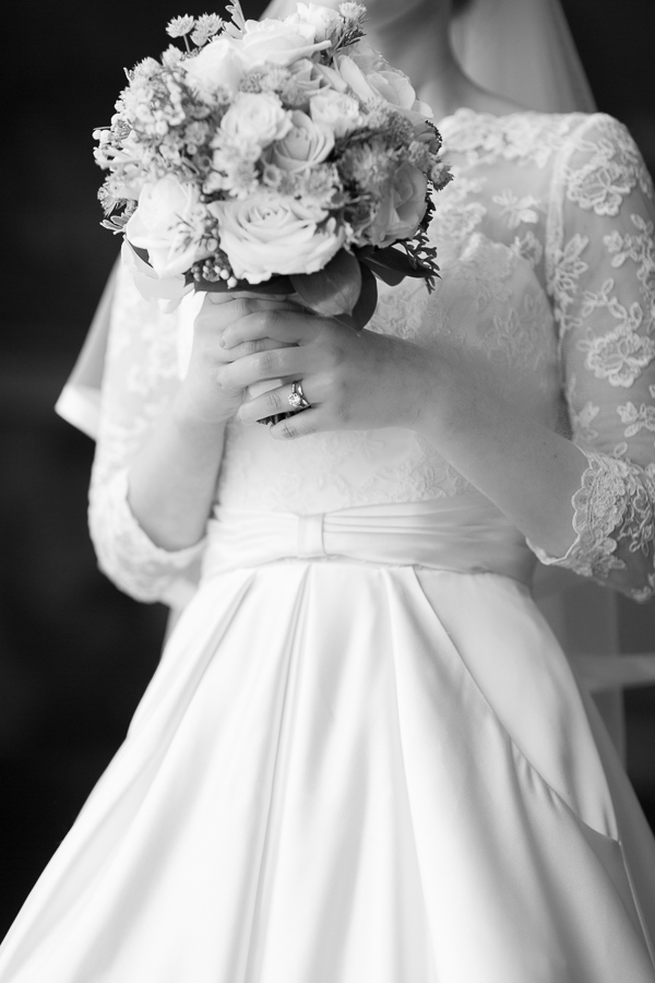 bride holding flowers, wedding ring visible