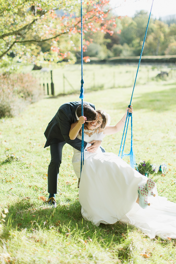 bride and groom embraced kissing on swing near glasgow