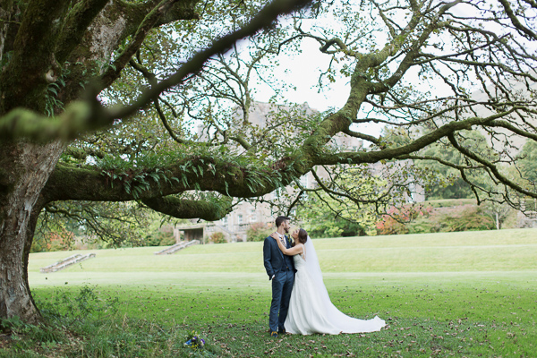 bride and groom under large tree in ardkinglas garden photo by fotogenic of scotland