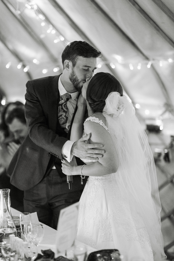bride and groom kissing during speeches