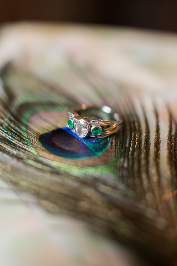 engagement ring with diamond and green stones on peacock feather