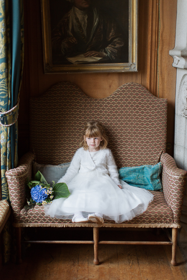 flower girl sitting looking through the window