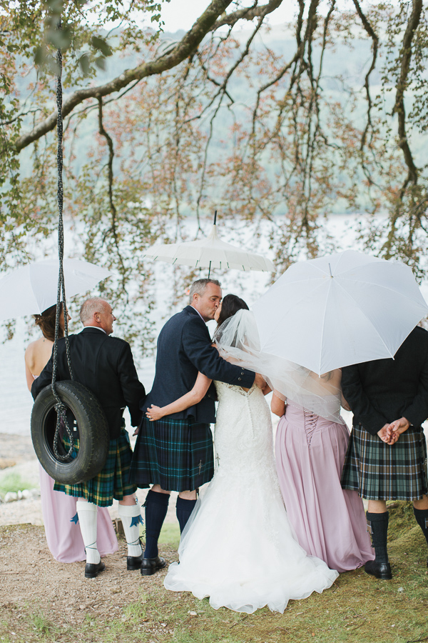 bridal party under big tree with umbrellas