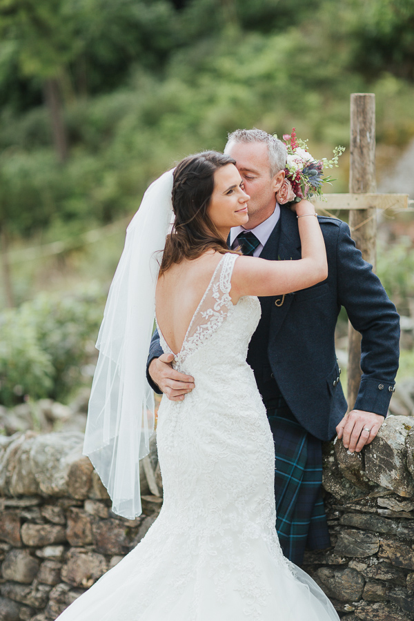 groom kissing bride on a cheek 