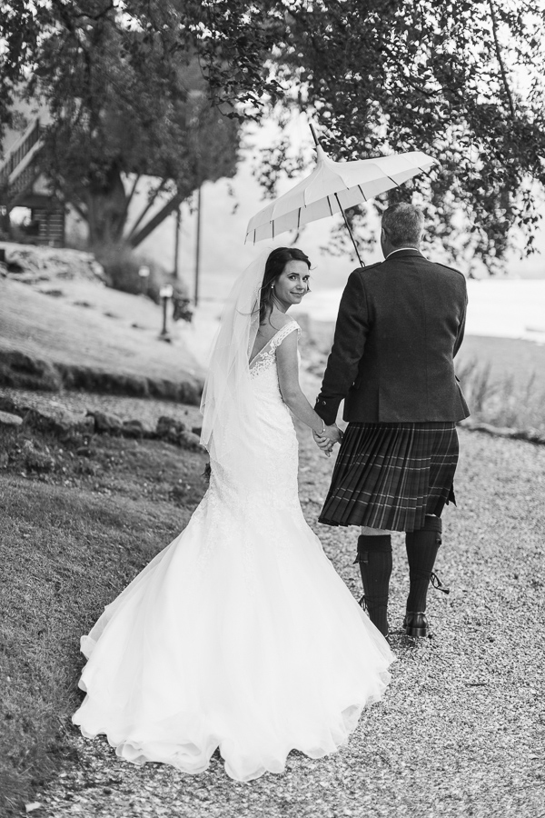 beck of the dress while bride and groom walking away