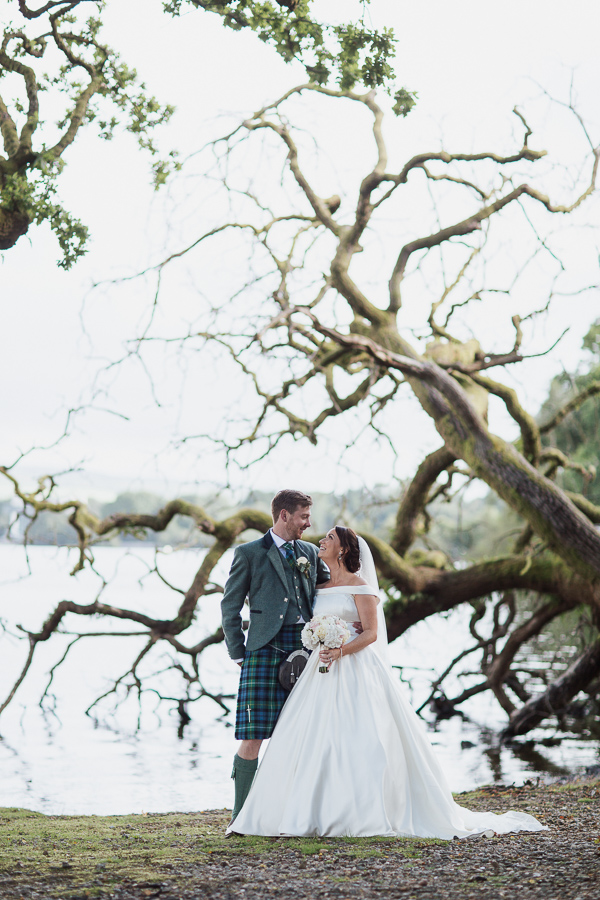 wedding photographer glasgow loch lomond fallen tree with bride and groom