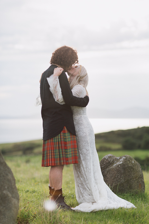bride and groom kissing on a scottish hill