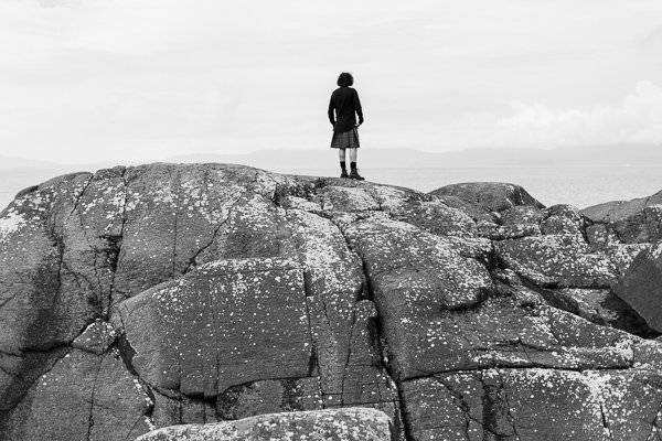 groom in a kilt on a rock looking at the view