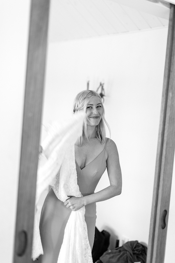 bride smiling holding her wedding dress
