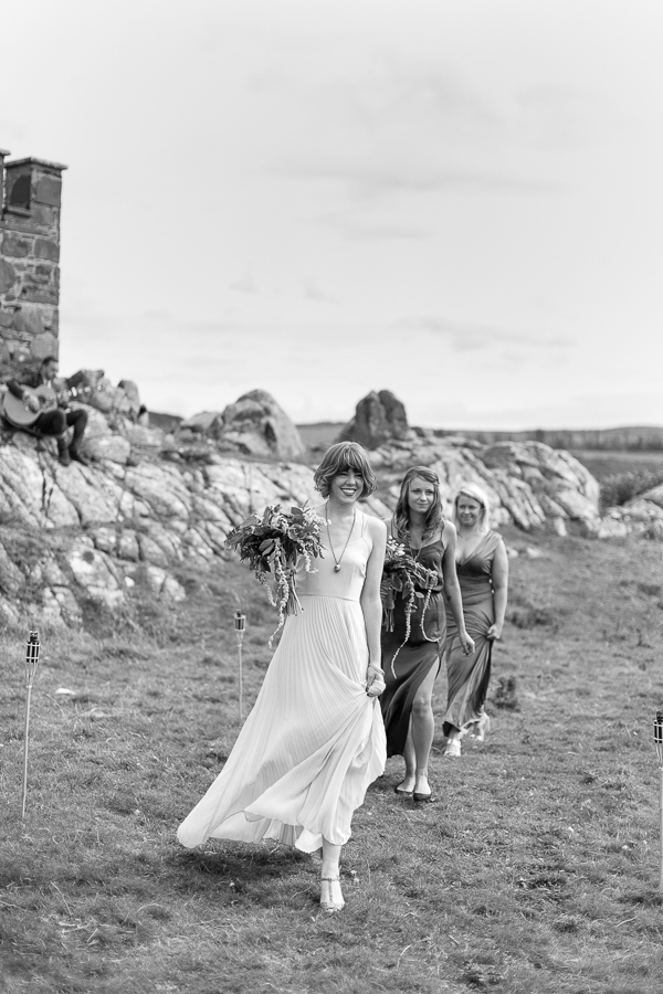 bridesmates gong down te aisle on the beach crear
