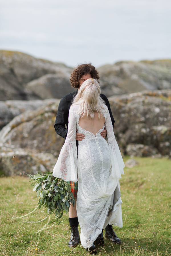 bride and groom kissing on a rocky beach
