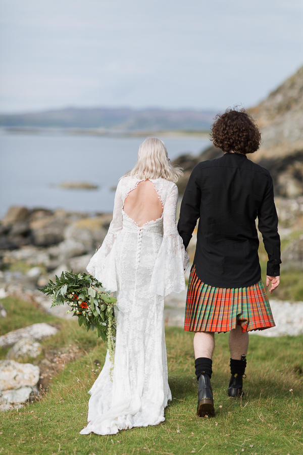 newlyweds walking toward beach view from back