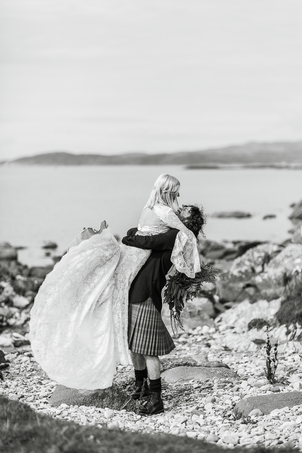 wedding photographers glasgow groom lifting bride on a beach