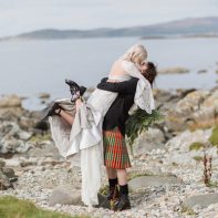 wedding photographer groom lifting bride on a rocky beach at crear scotland wedding
