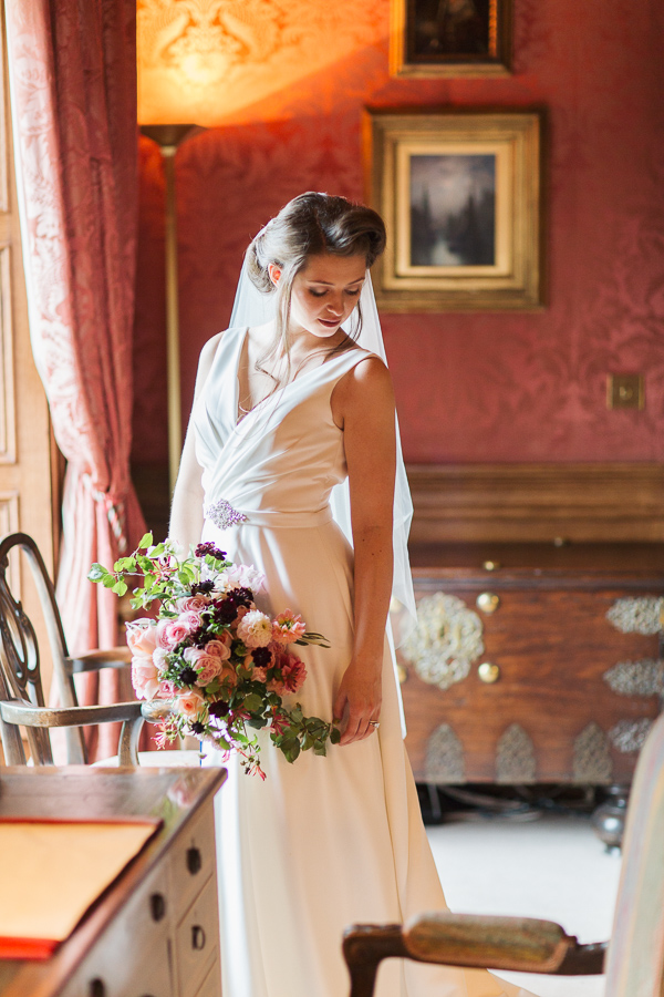 bride looking down at her dress holding flowers fotogenic of scotland
