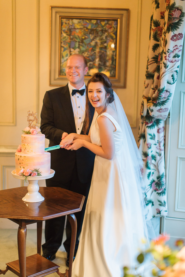 newlyweds cutting cake and laughing