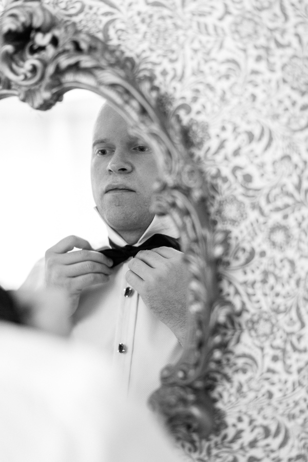 groom putting his bowtie