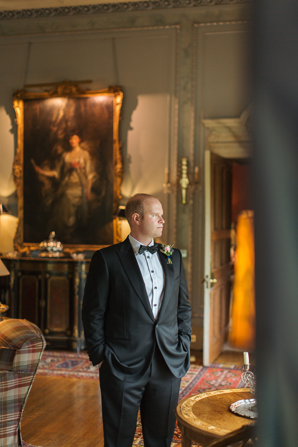 groom looking through the window at dundas castle near edinburgh