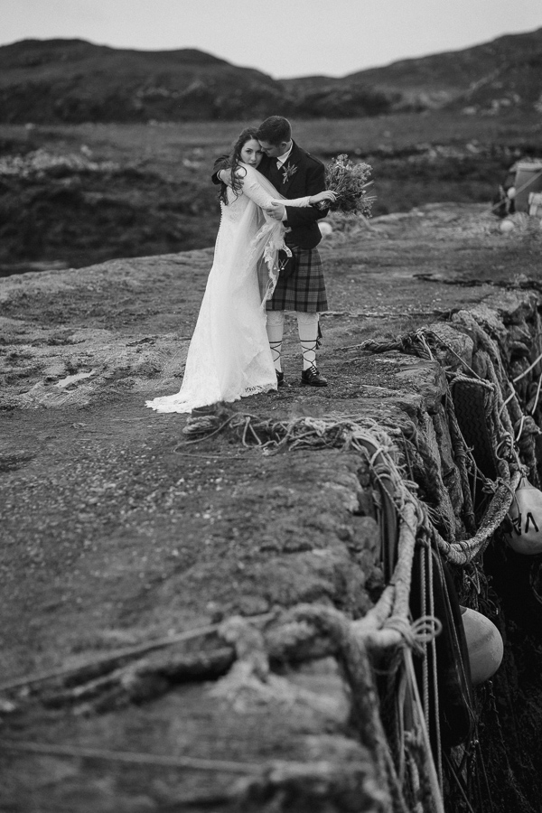 newlyweds embraced standing on an old pier