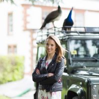 portrait of engaged girl with landrover and peacocks