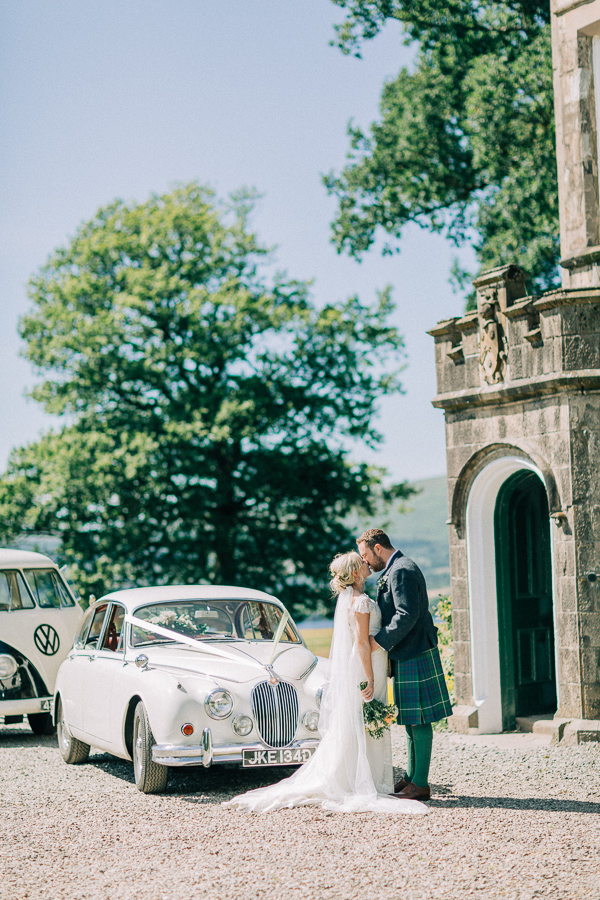 couple kissing outside of a castle loch lomond 
