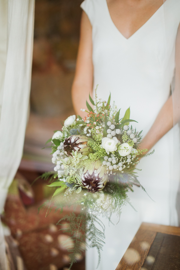 bride holding flowers view through the window