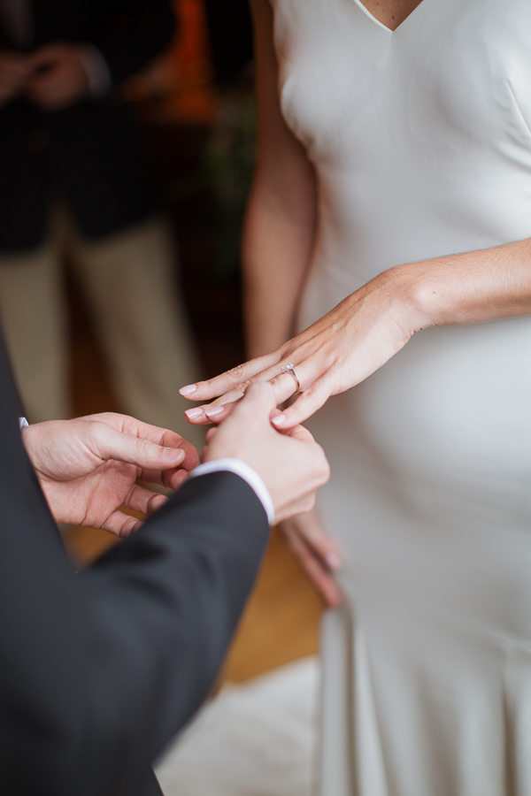 groom is putting ring on 