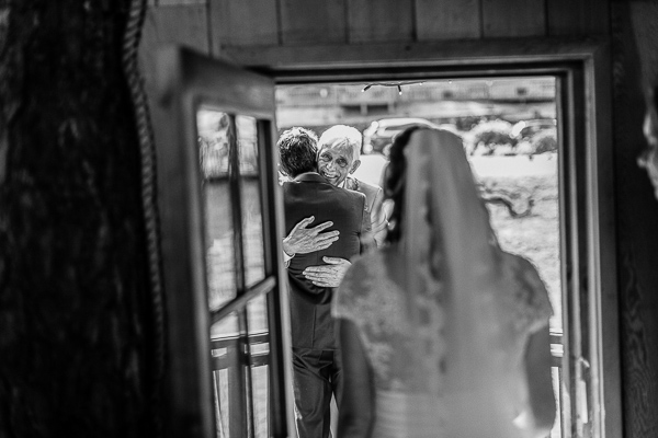 dad embracing groom after wedding