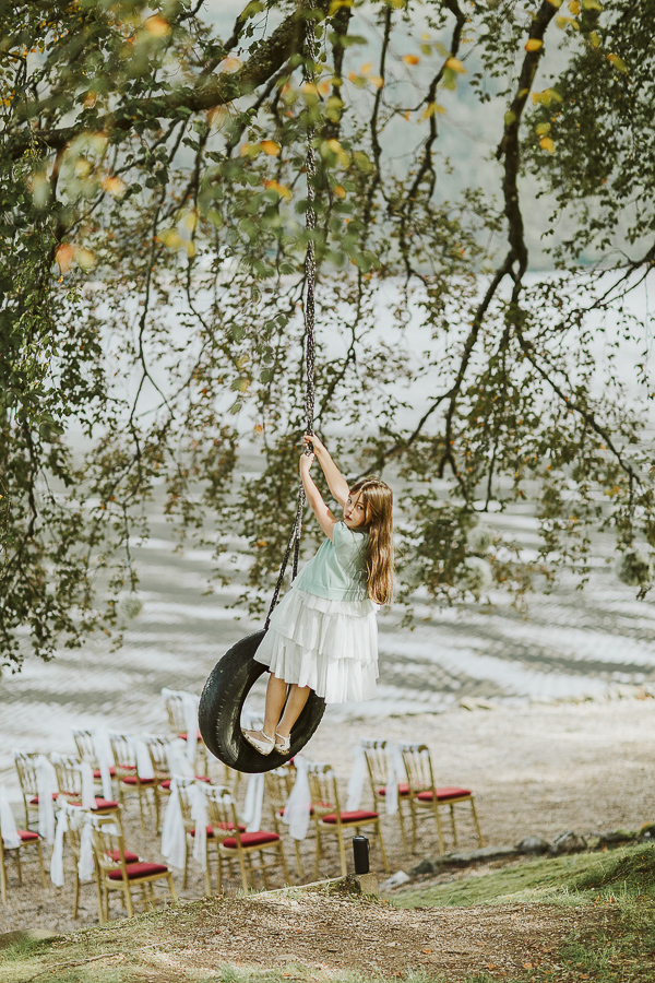 grils swinging on a tire at the lodge on loch goil in scotland